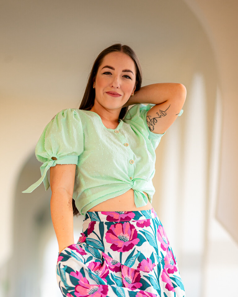 Žena pózuje v starom meste v bavlnenej blúzke od Love Colors